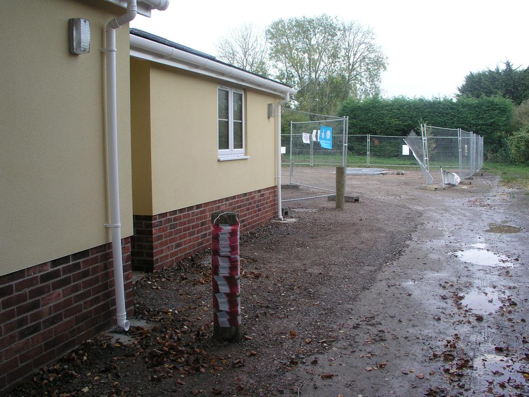 Entrance to car park with servery on left and posts to prevent impact on walls and drains.